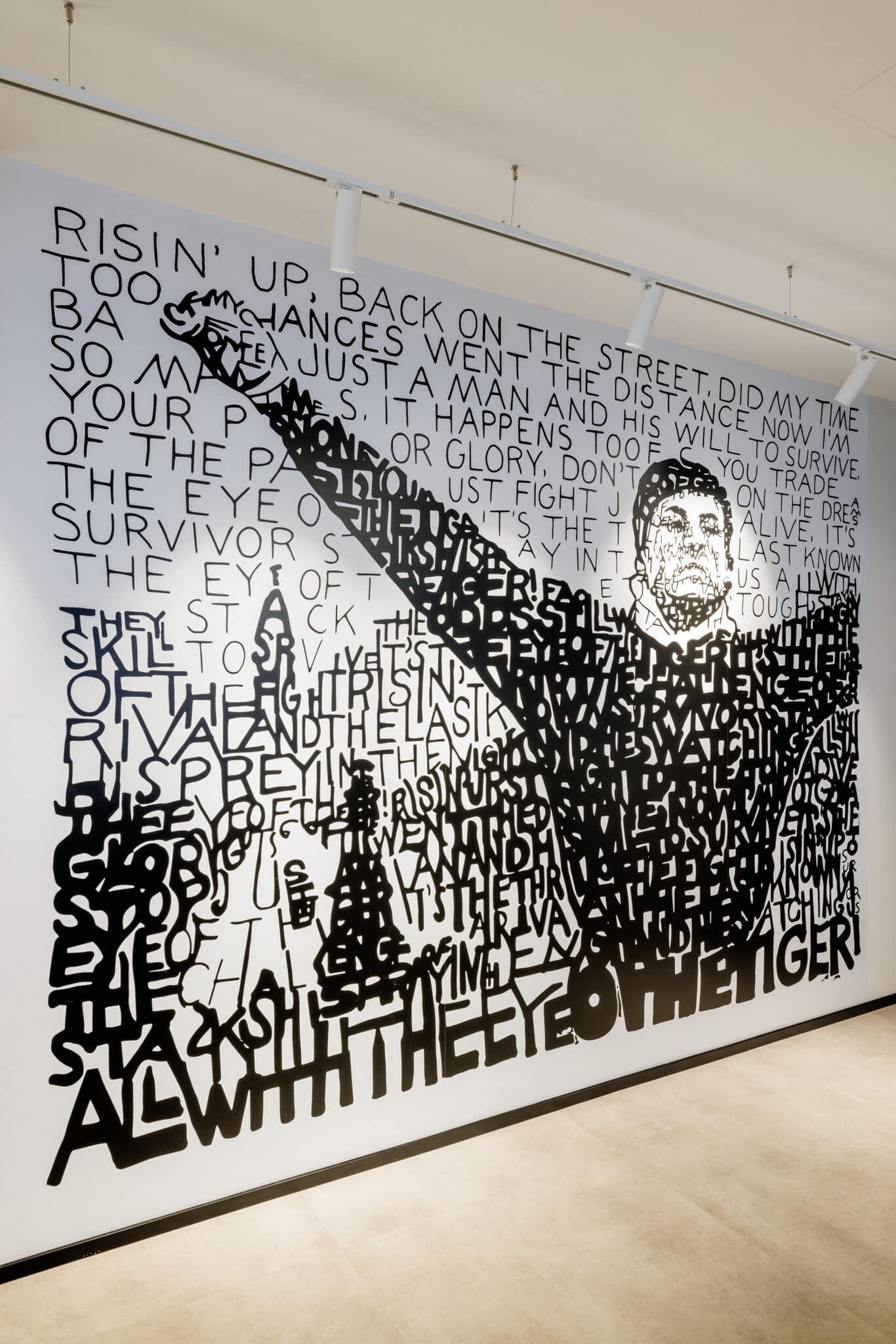Typographic wall graphic forming a boxer figure in a gallery space