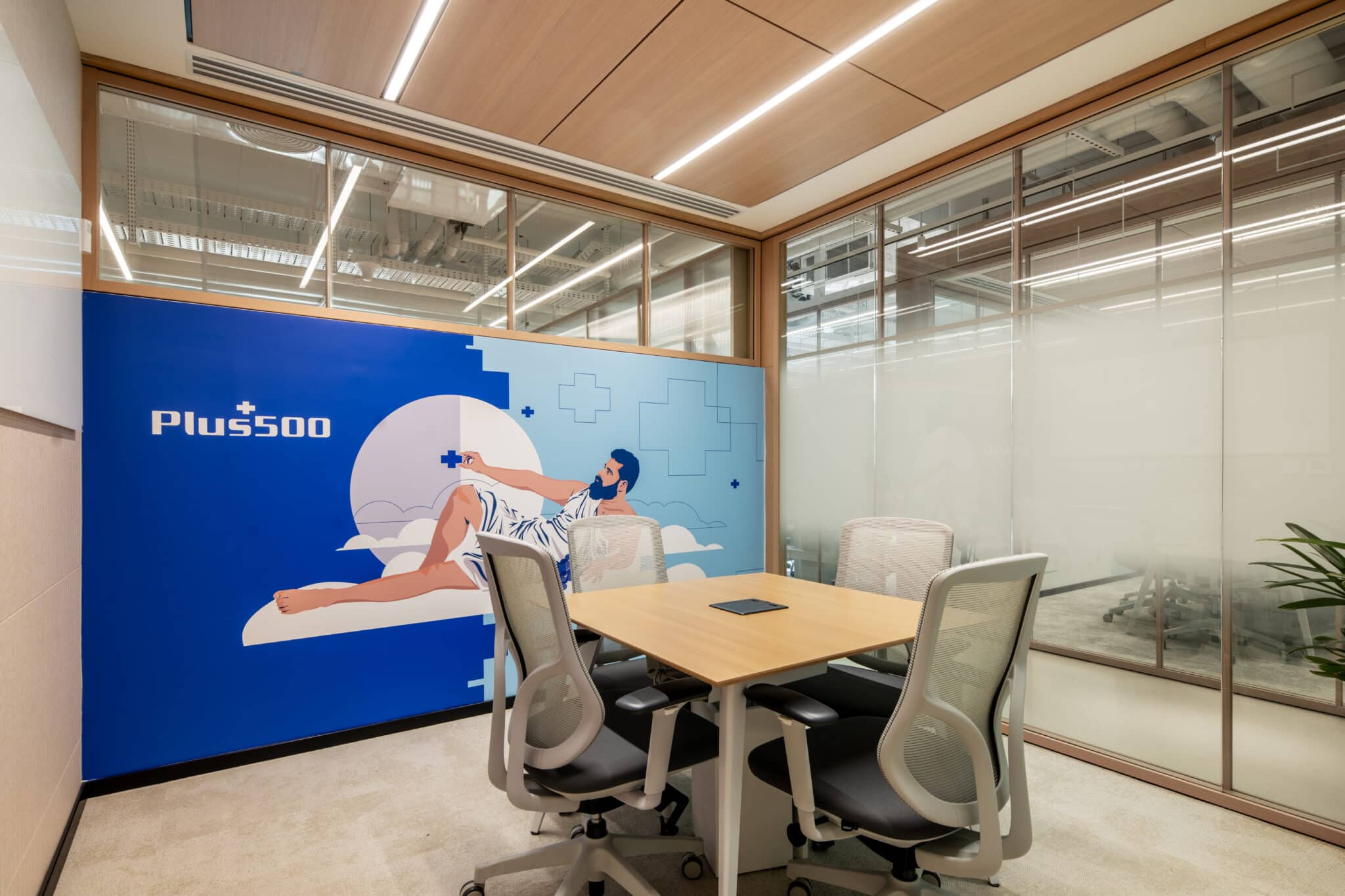 Blue wall graphic of a figure on clouds with the Plus500 logo