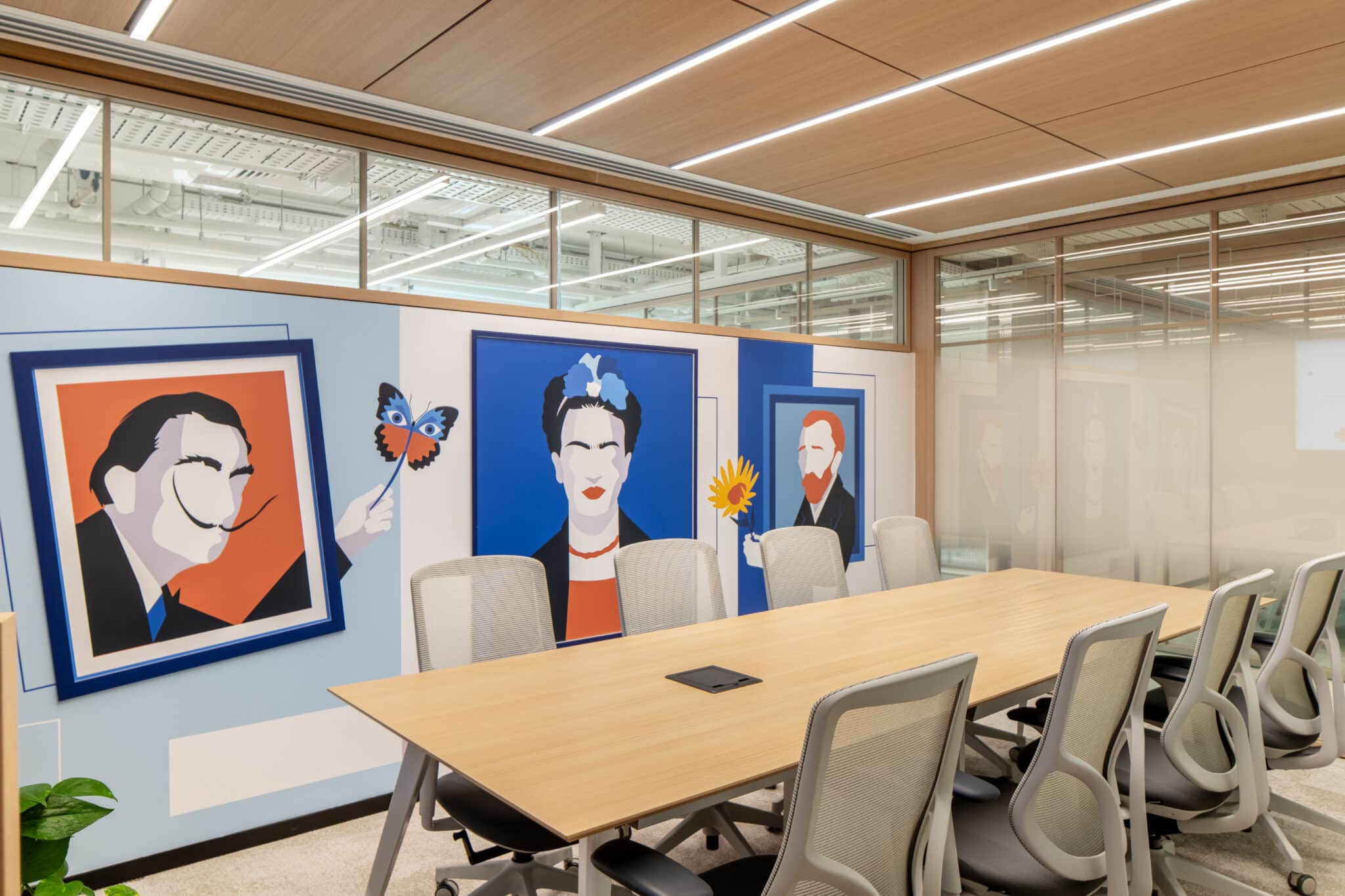 Three framed artist portraits on a meeting room wall