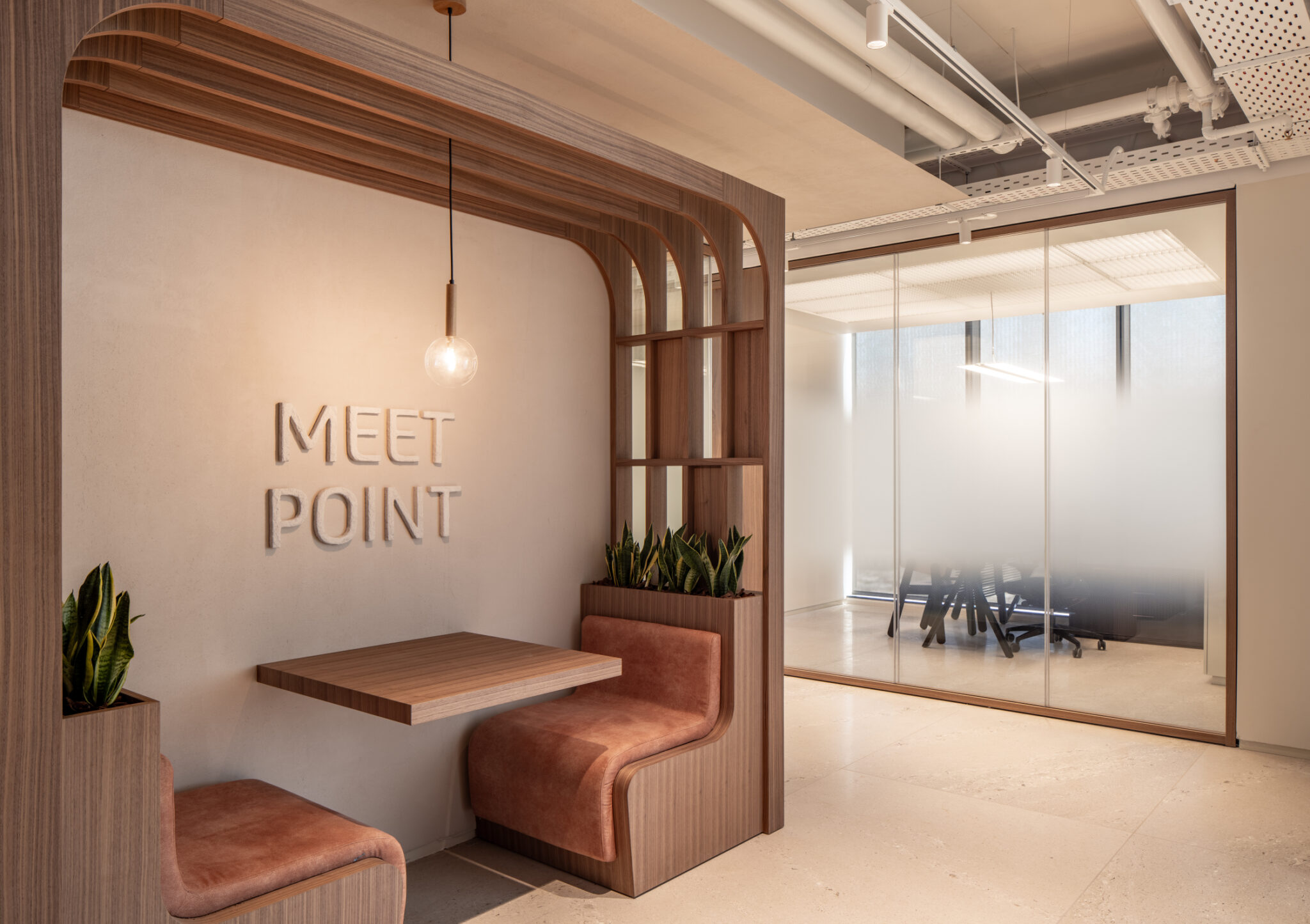 MEET POINT letters recessed into a plaster wall in a booth