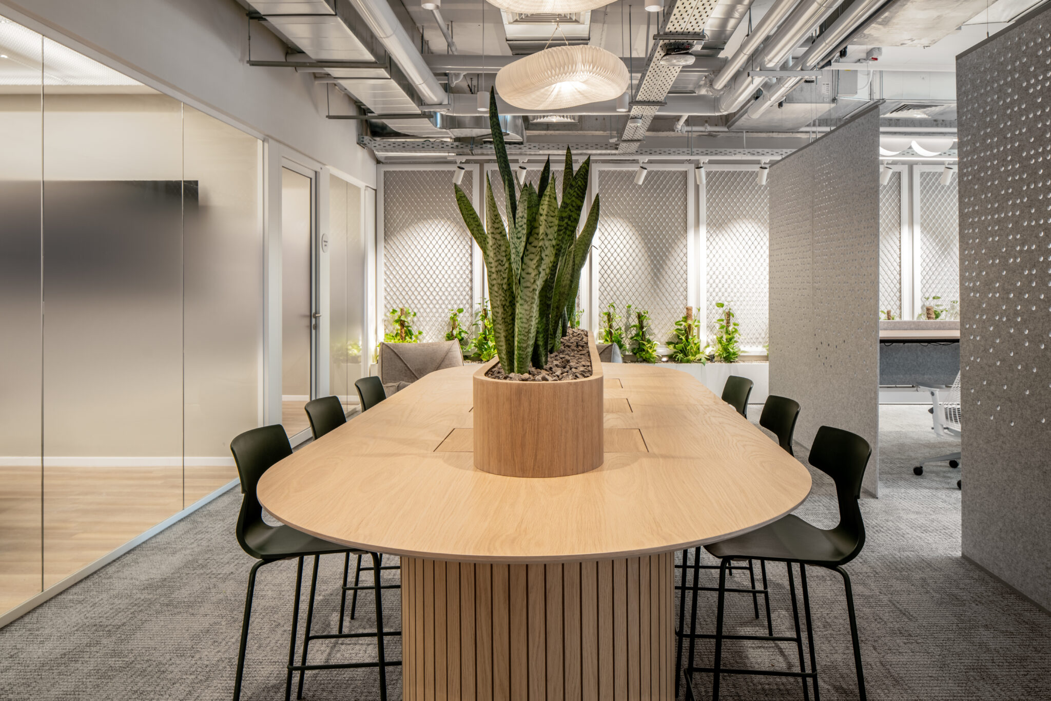 Perforated pattern wall panels around a meeting table