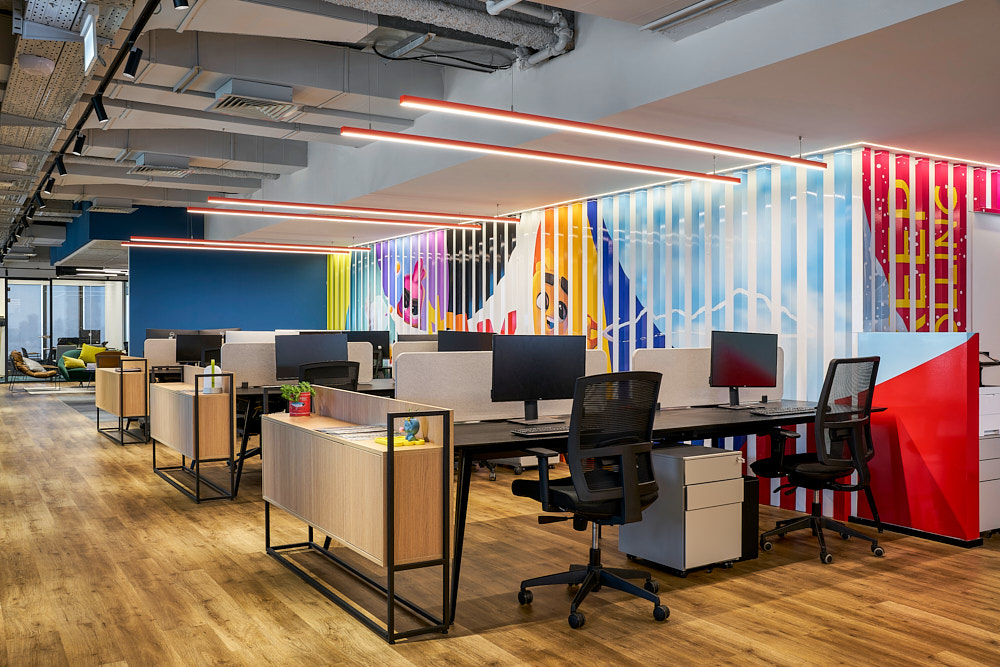 Printed slat wall with KEEP ROLLING lettering behind open plan desks