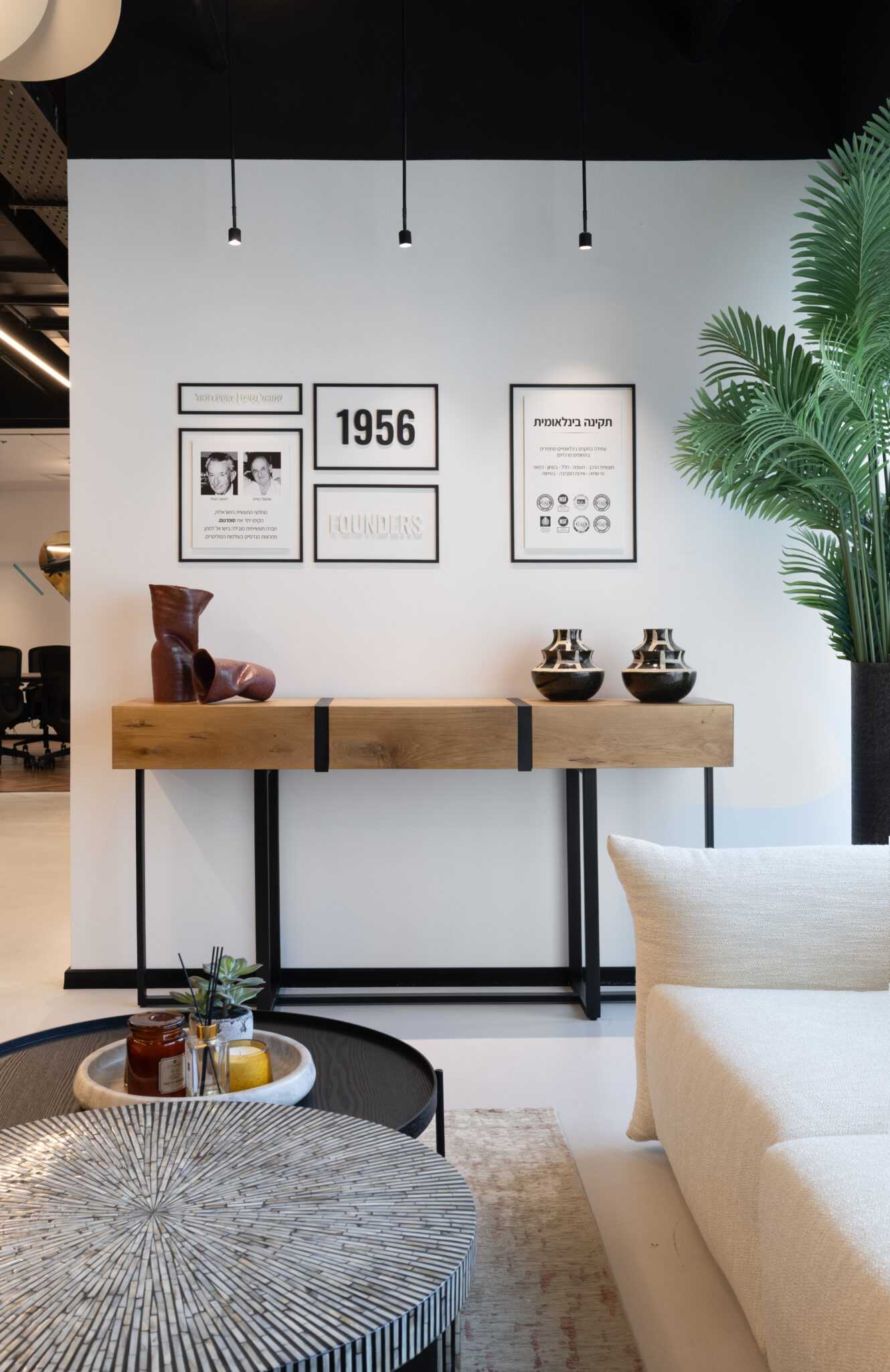 Framed pictures of the company history above a console table