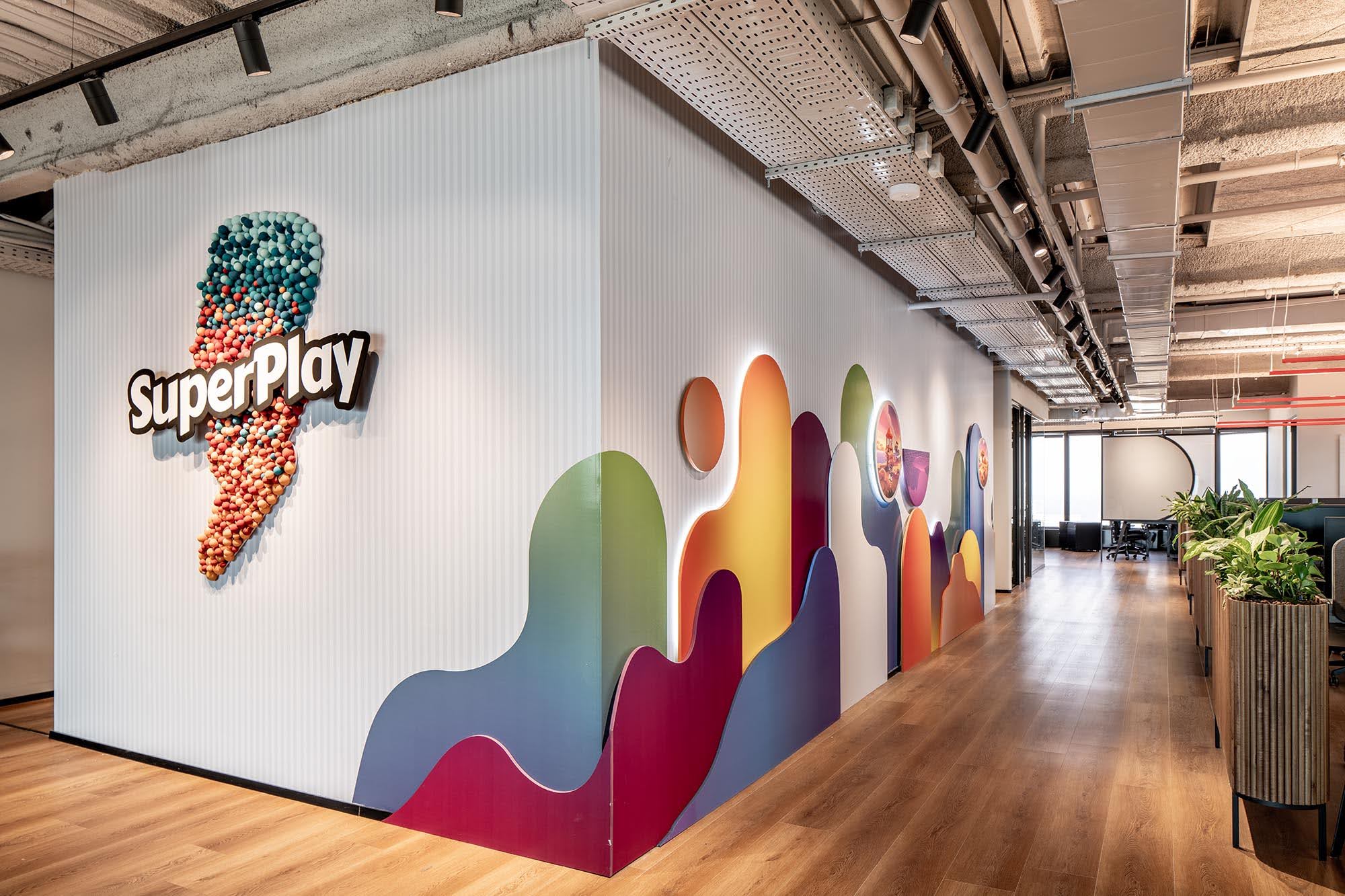 SuperPlay 3D logo on a fluted wall with layered colour shapes