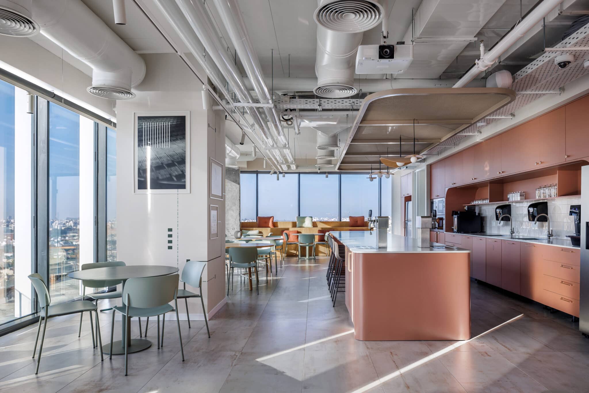 Office kitchen with terracotta cabinets and a framed print on the wall
