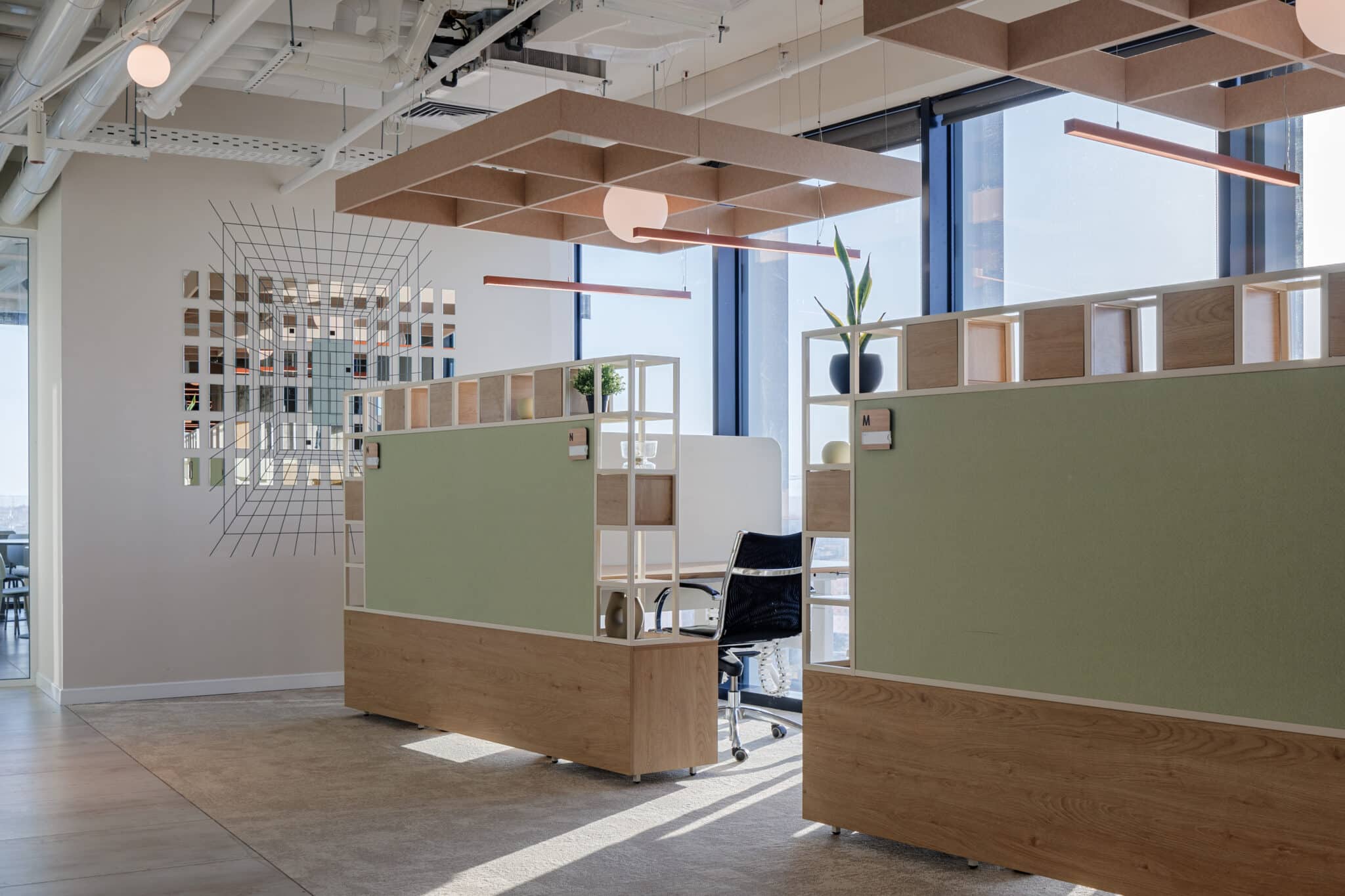 Wire grid wall artwork beside desk dividers with shelving