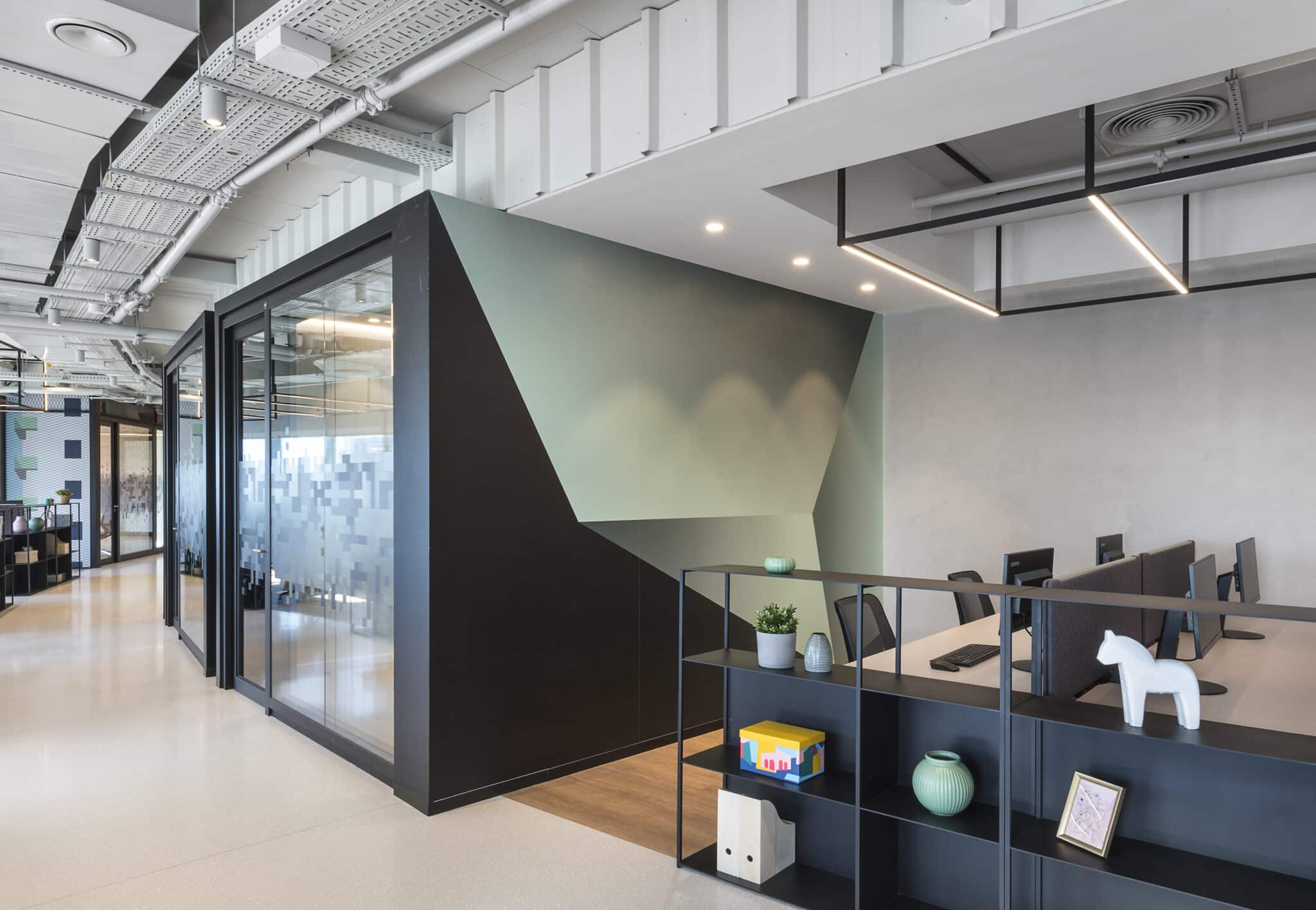 Green gradient wall graphic next to a dark meeting room