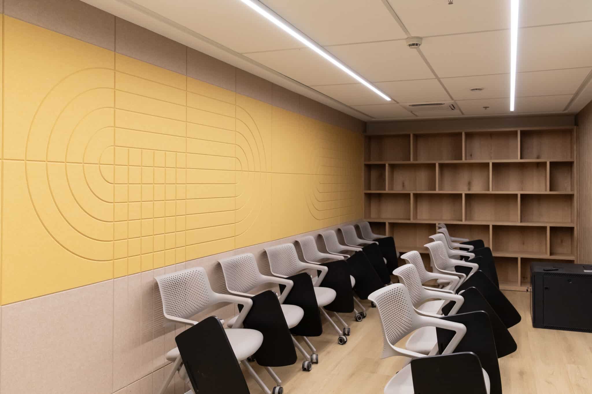 Yellow acoustic felt panels with a routed pattern in a training room