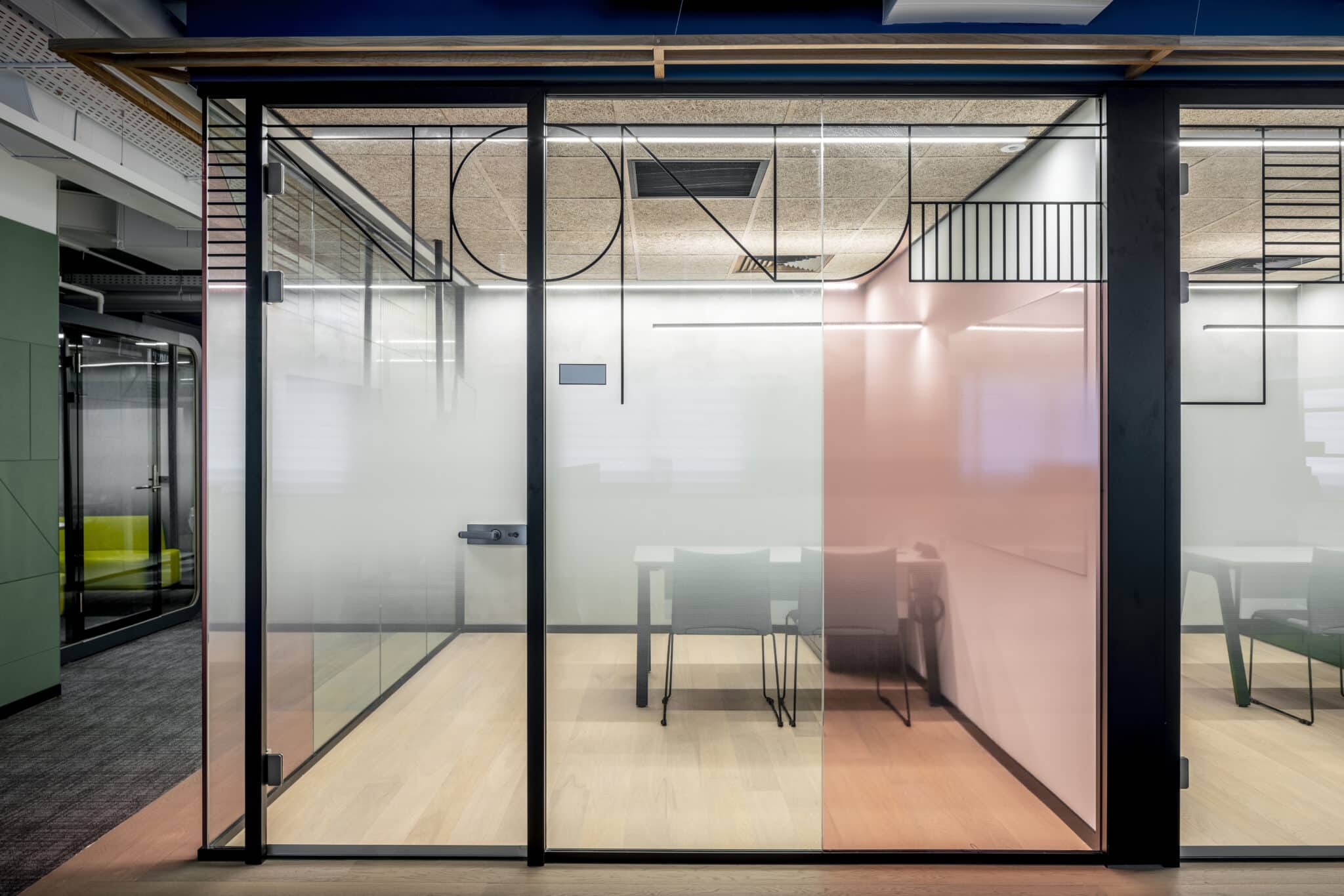 Gradient film on glass meeting room walls in coral and grey