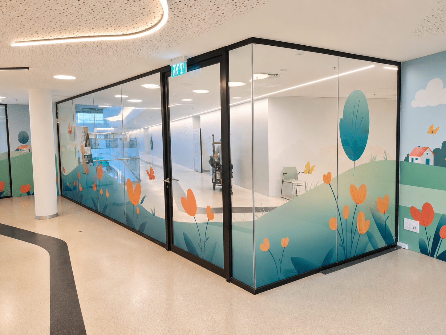 Illustrated landscape printed on glass partitions in a corridor