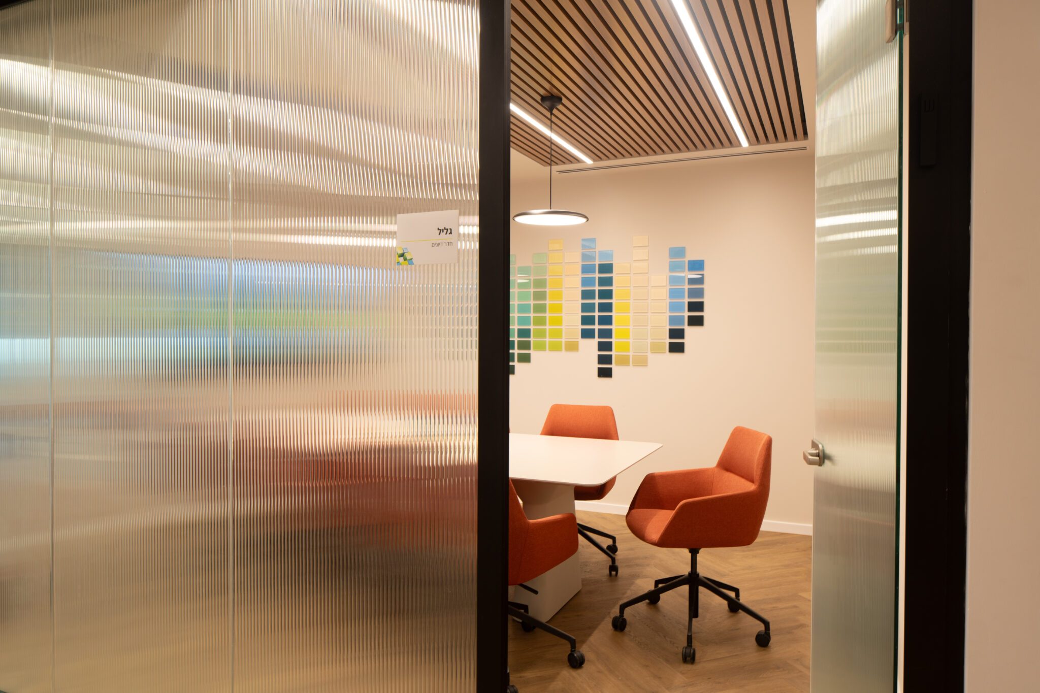 Fluted glass meeting room wall with a small room sign