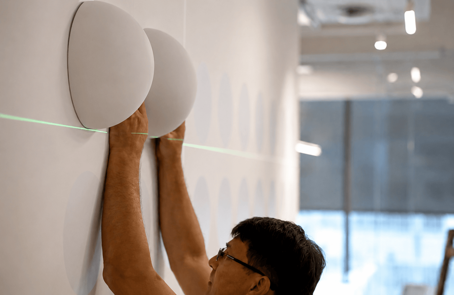 Installer fitting round wall panels using a laser line