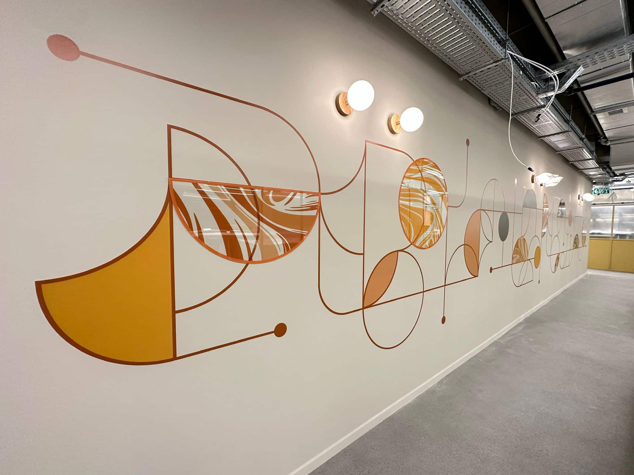 Curved line wall graphic in orange along a corridor