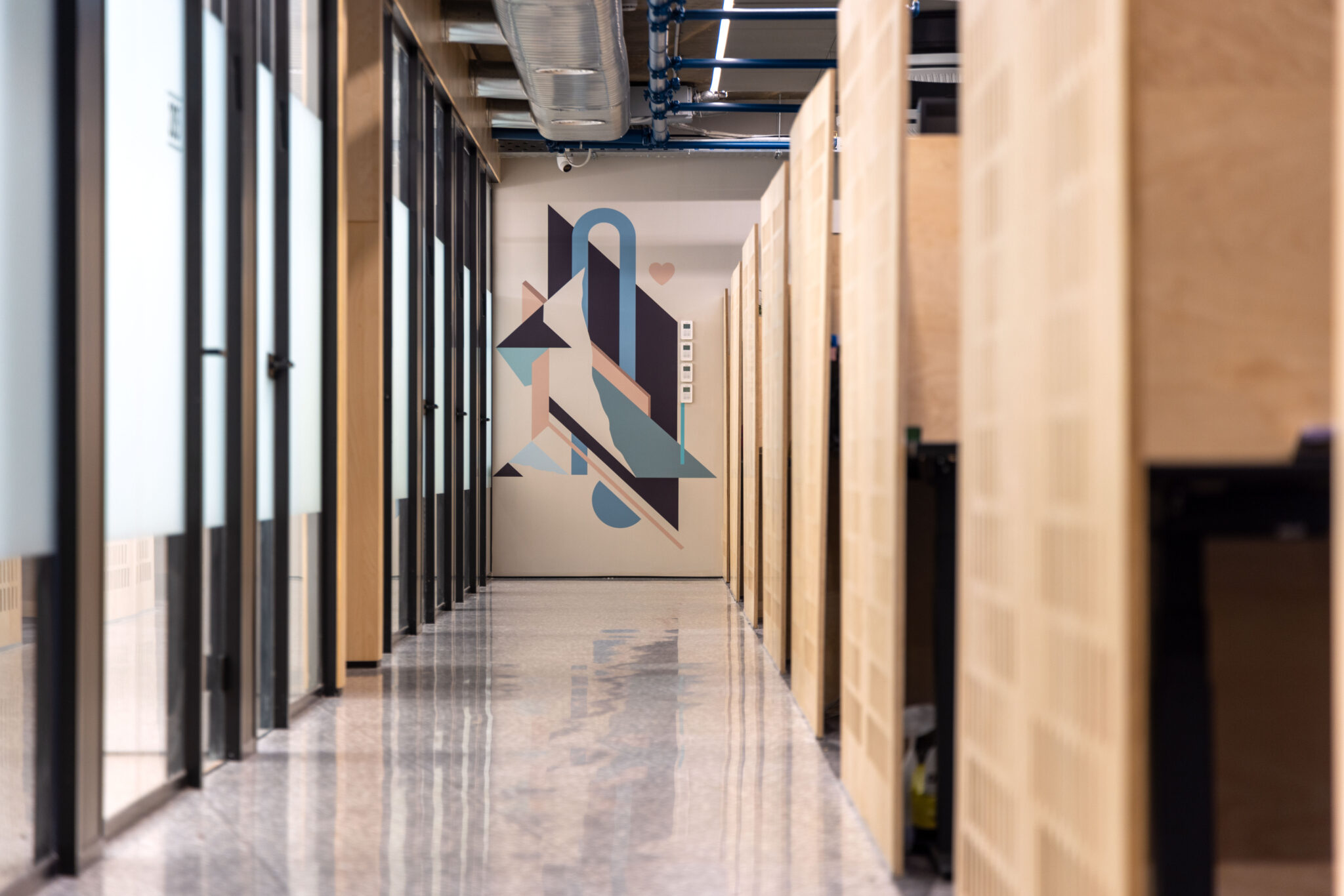 Geometric wall graphic in blue and black at the end of a corridor