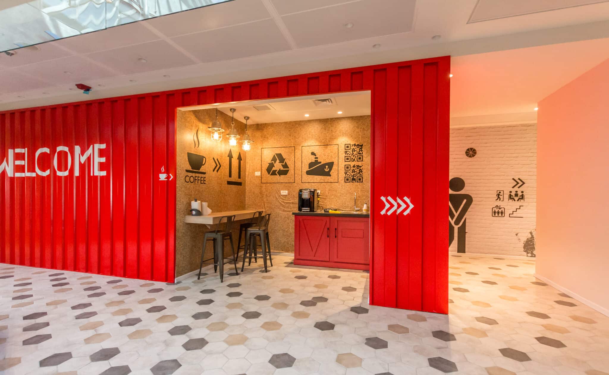 WELCOME lettering and pictograms on a red container facade