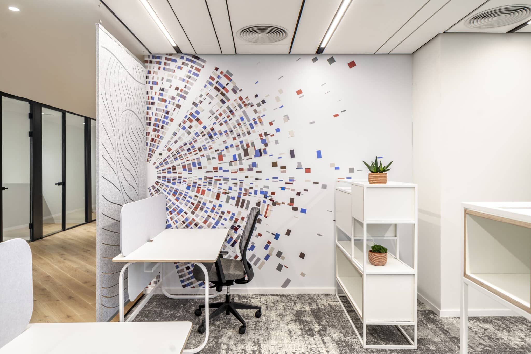 Scattered square graphics next to a carved acoustic felt panel
