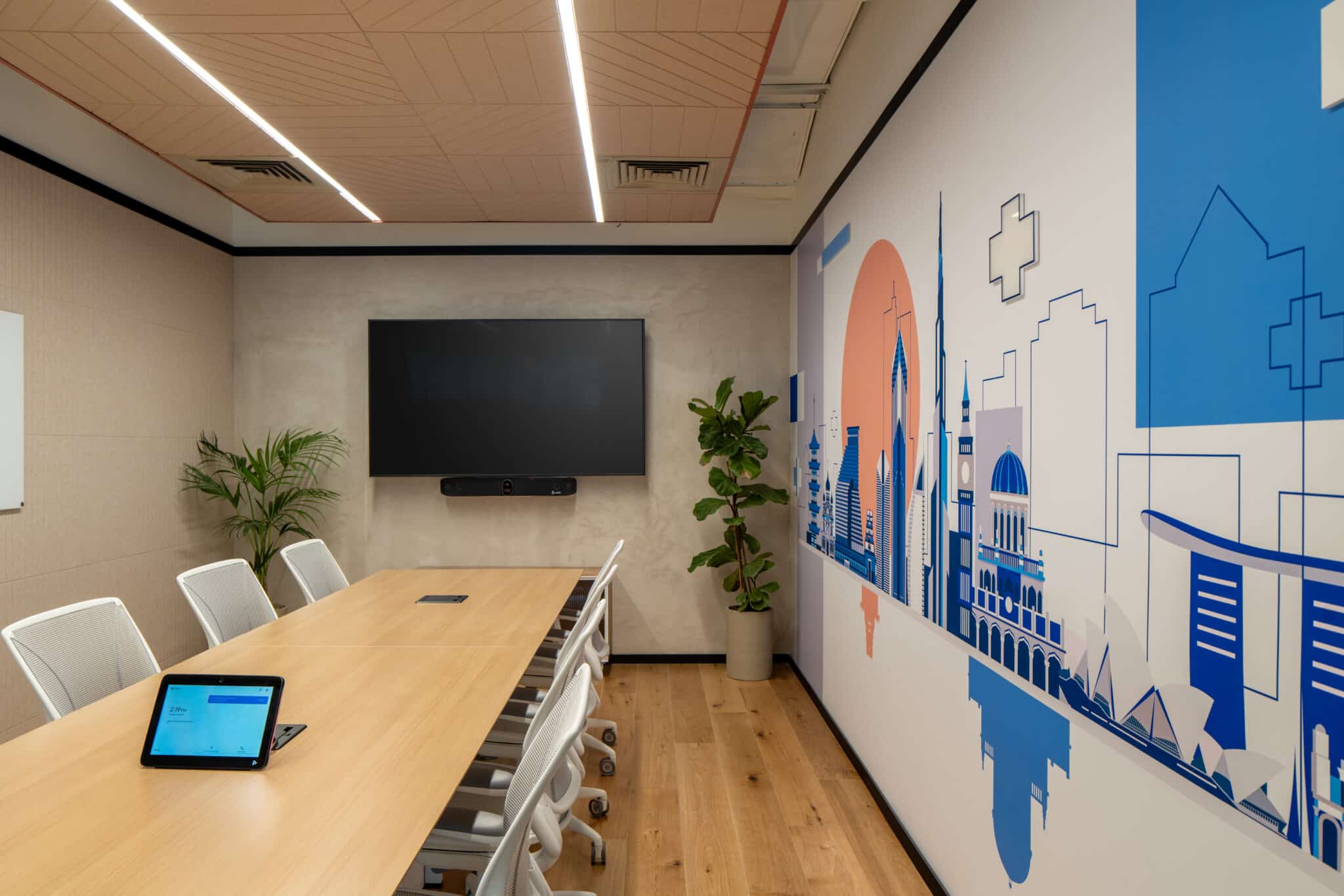 Wall graphic of a city skyline in blue and coral in a meeting room