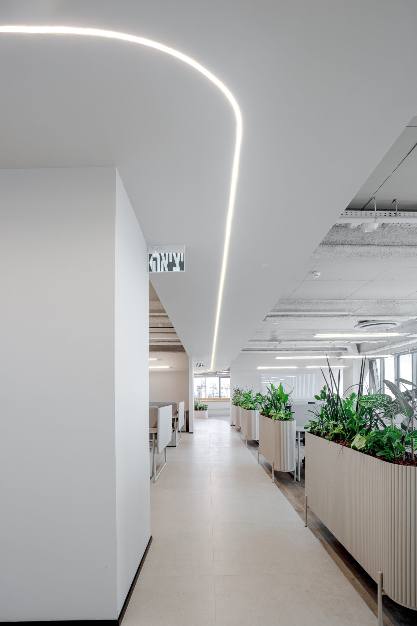 Curved lit line running along an office corridor ceiling
