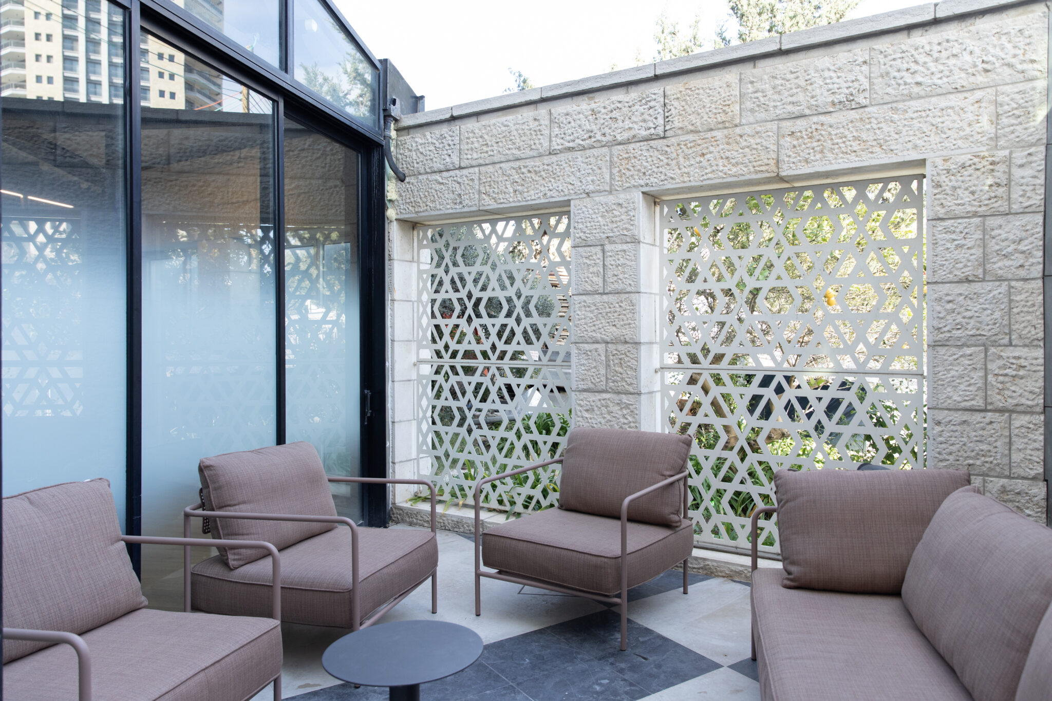 Frosted glass wall beside a terrace with perforated screens