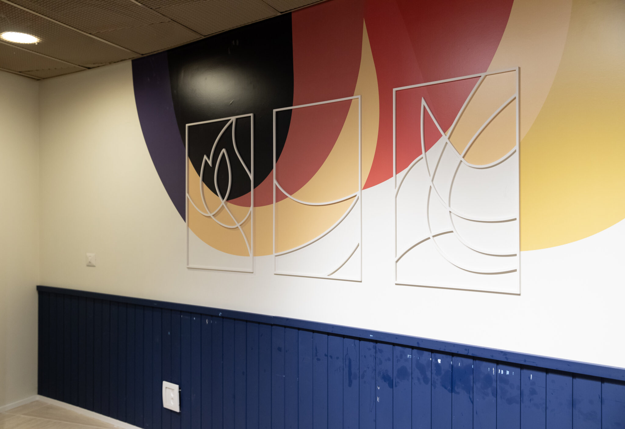 Thin metal frame outlines over an abstract colour wall graphic