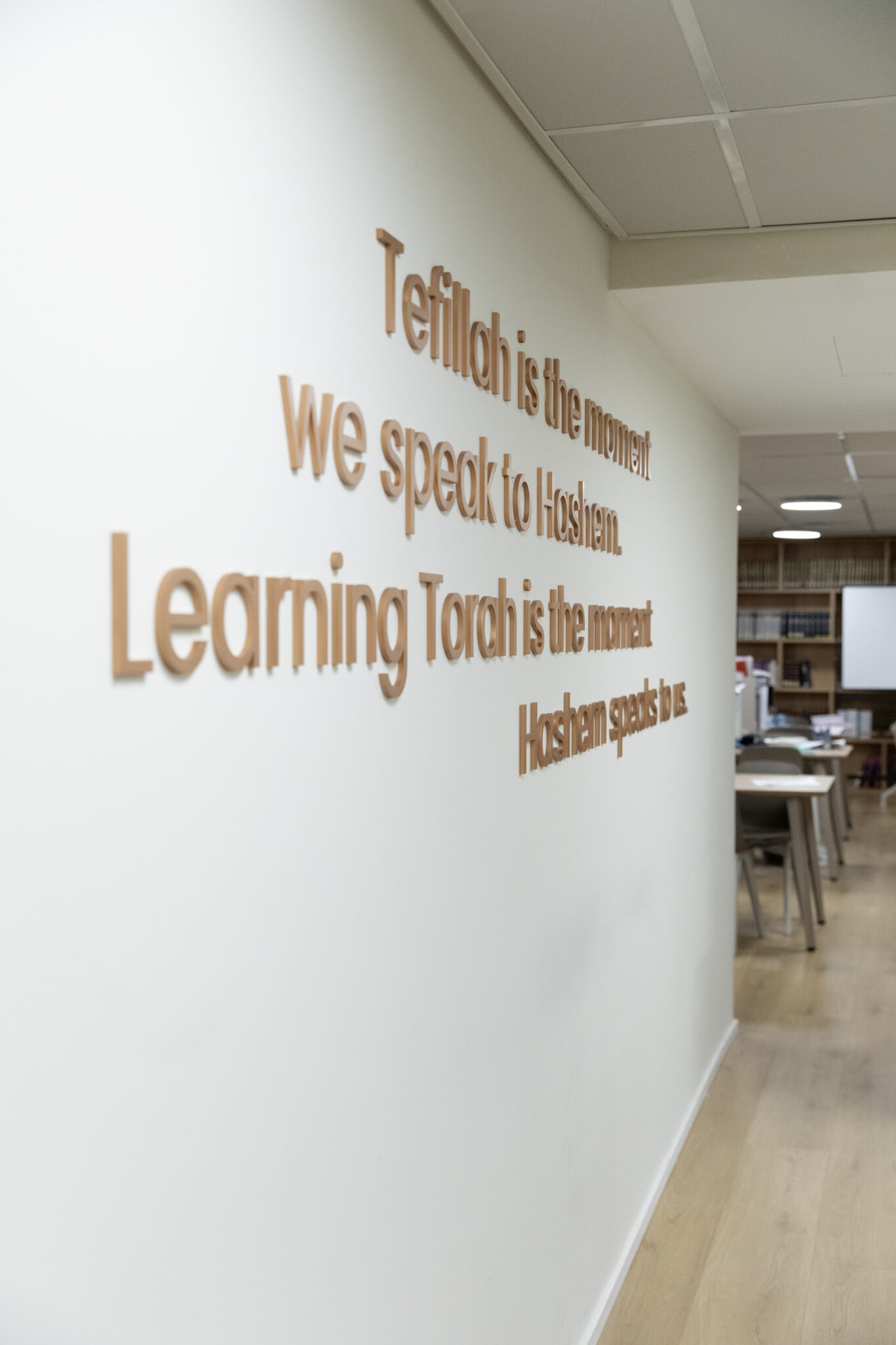 Copper 3D quote letters running along a study room wall