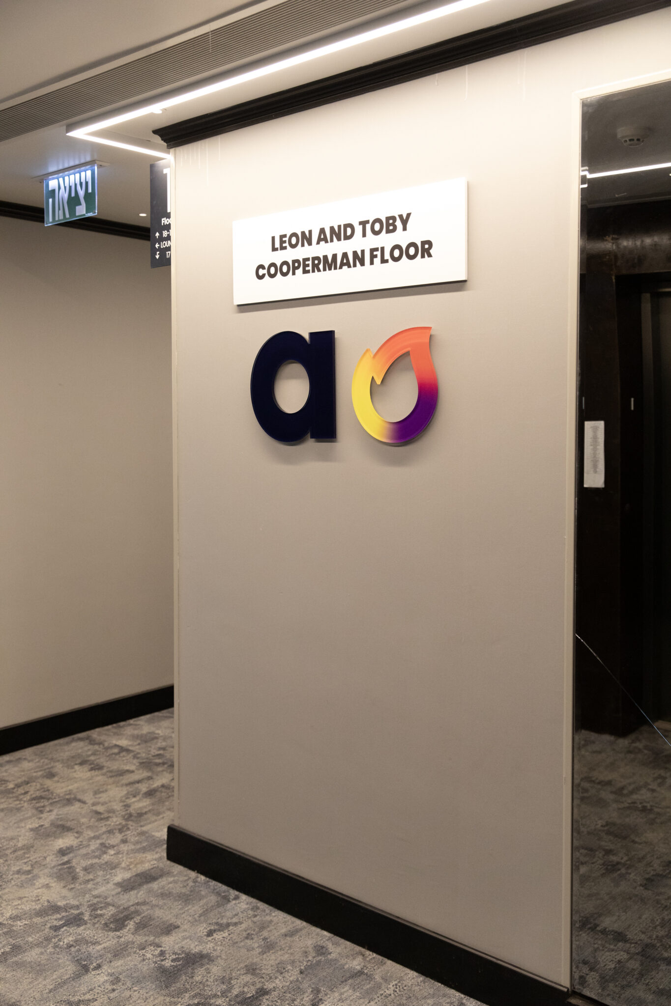 aish logo mark with a donor floor plaque beside the lifts