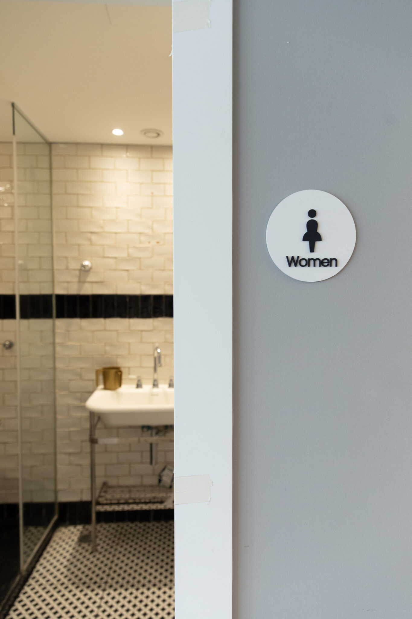Women sign on a washroom door frame